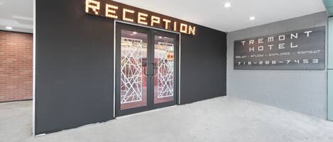 A hotel reception area with a modern design, featuring a reception desk and a sign that reads "RECEPTION".