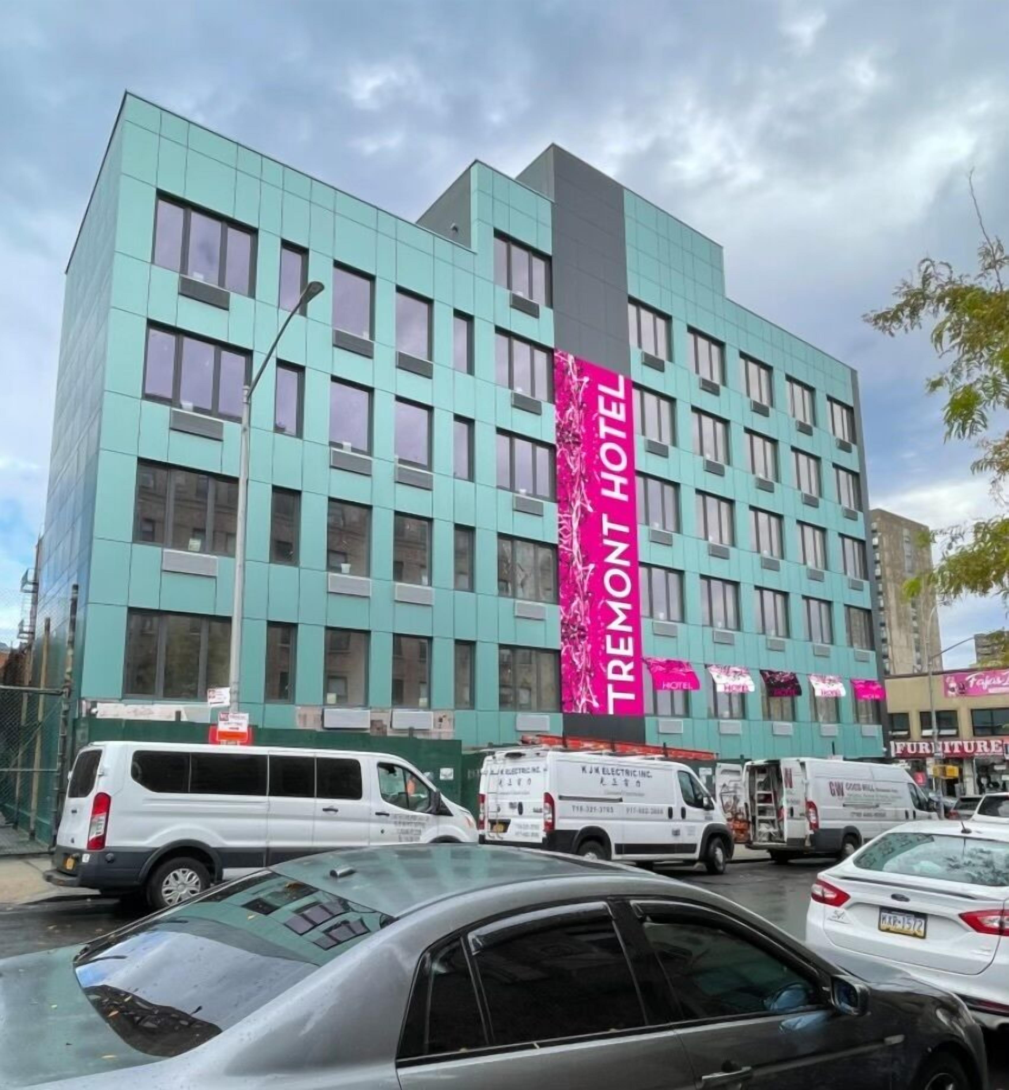 A modern hotel building with a prominent vertical sign reading "TREMONT HOTEL".