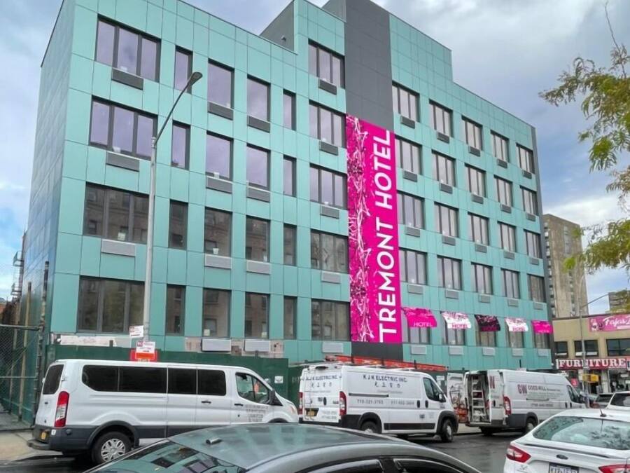 A modern hotel building with a prominent vertical sign reading "TREMONT HOTEL".