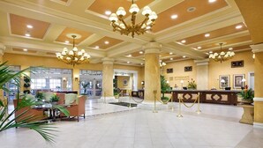 A spacious lobby with a reception desk, chandeliers, and seating areas. - A fabulous vacation retreat just one block from the Las Vegas Strip. (Las Vegas)