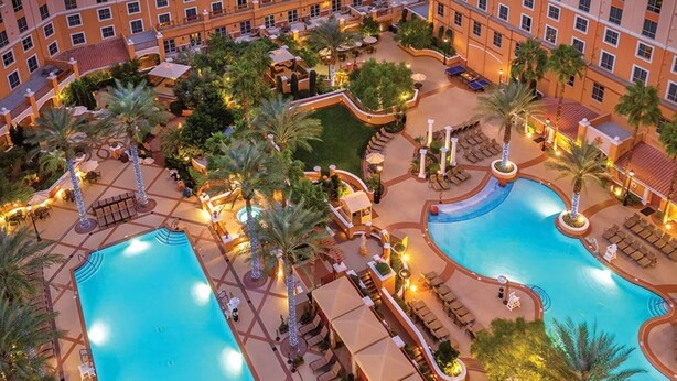 A resort with two large swimming pools, palm trees, and outdoor seating areas. - A fabulous vacation retreat just one block from the Las Vegas Strip. (Las Vegas)