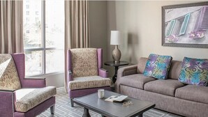 A hotel room with a sofa, armchair, and a small table with a lamp and a book. - A fabulous vacation retreat just one block from the Las Vegas Strip. (Las Vegas)