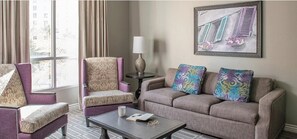 Relax in a comfortable seating area with a sofa and armchair, perfect for reading a book by the window.
