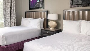 A hotel room with two beds, a nightstand with a lamp, and a window with curtains. - A fabulous vacation retreat just one block from the Las Vegas Strip. (Las Vegas)