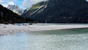 A clear lake with rocky shore, surrounded by mountains and trees. - Eco-Chalet Matschiedl
Luxury mountainside Eco Chalet with stunning view -  (Kärnten)