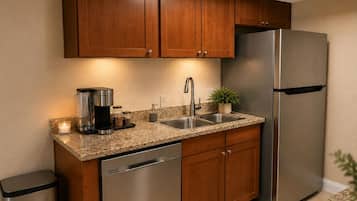 A kitchen with wooden cabinets, a stainless steel refrigerator, a coffee maker, and a sink.