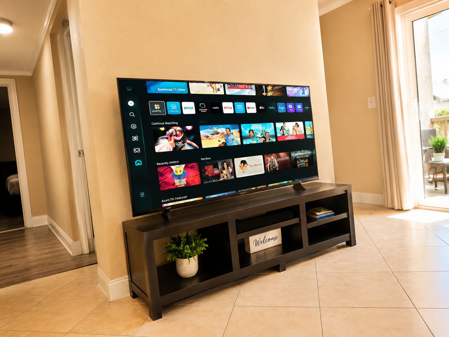 Een flatscreen-tv bevestigd aan een donkerhouten standaard, met een 'Welcome' bordje, waarop een streamingdienstinterface met diverse contentopties wordt getoond.