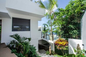 Stunning multi-level residence with an outdoor space and pool, surrounded by lush greenery.