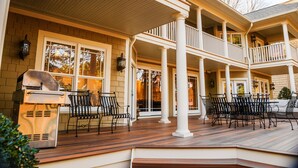 Un espacio exterior techado con diferentes distribuciones de asientos y una parrilla.