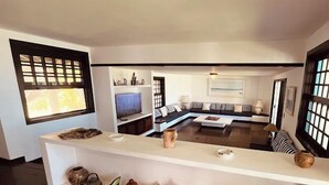 Ein modernes Wohnzimmer mit einem Ecksofa, einem Couchtisch und einer langen Ablage mit dekorativen Gegenständen.