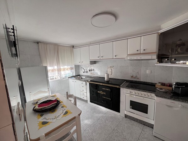 A kitchen with white cabinets, a stove, oven, and a sink. - A house where you can enjoy Valdeorras, El Bierzo, or the Médulas Natural Park, (Pumares)