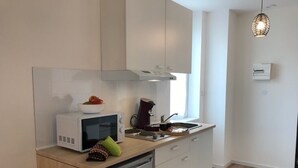 A modern kitchen with a microwave, kettle, and sink. - Cozy and bright studio for 2 (Mulhouse)