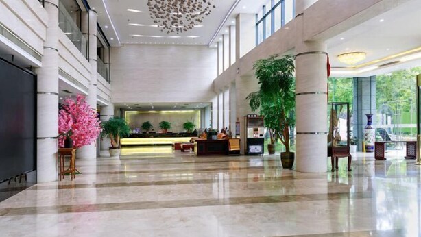 A spacious lobby with a reception desk, seating area, and large windows. - Jiutong Haiyuan International Hotel (Wuhan)