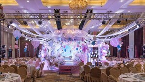 A banquet hall with round tables, a stage with a backdrop, and a chandelier. - Jiutong Haiyuan International Hotel (Wuhan)