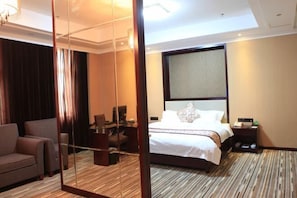 A hotel room with a large bed, a desk, a chair, and a mirror. - Jiutong Haiyuan International Hotel (Wuhan)