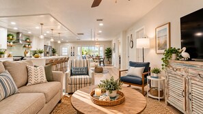 A spacious living room with a sofa, armchairs, a coffee table, and a dining area in the background. - STUNNING! Game Room, Pool, Beaches & Full Remodel! (Bradenton)