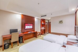 A hotel room with a bed, a desk, a television, and a wardrobe. - Hongtai Hotel (Baofeng)