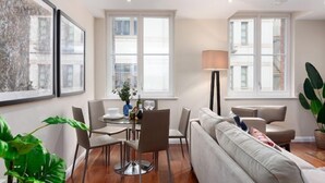 A modern living room with a sofa, dining table, chairs, and large windows. - Chancery Lane, Central London by Interhome (London City)