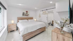 A bedroom with a wooden bed, a nightstand, a dresser, and a mirror. - Lakefront Oasis In Hollywood | Hard rock casino (Fort Lauderdale)