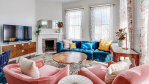 A living room with a fireplace, a television, a sofa, and a coffee table. - High Style, Fun Decor, Awesome Location! 117D by Forsyth Park (Savannah)
