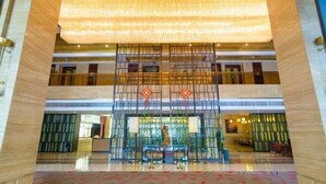 A spacious lobby with a large chandelier, a reception desk, and a seating area. - Shuixi Hotel (Qianxi)