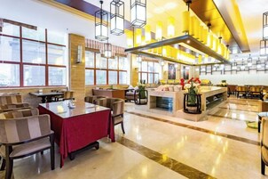 A spacious restaurant with high ceilings, large windows, and modern lighting fixtures.