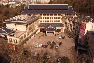 Un edificio de varios pisos con un patio central, zona de estacionamiento y múltiples accesos.