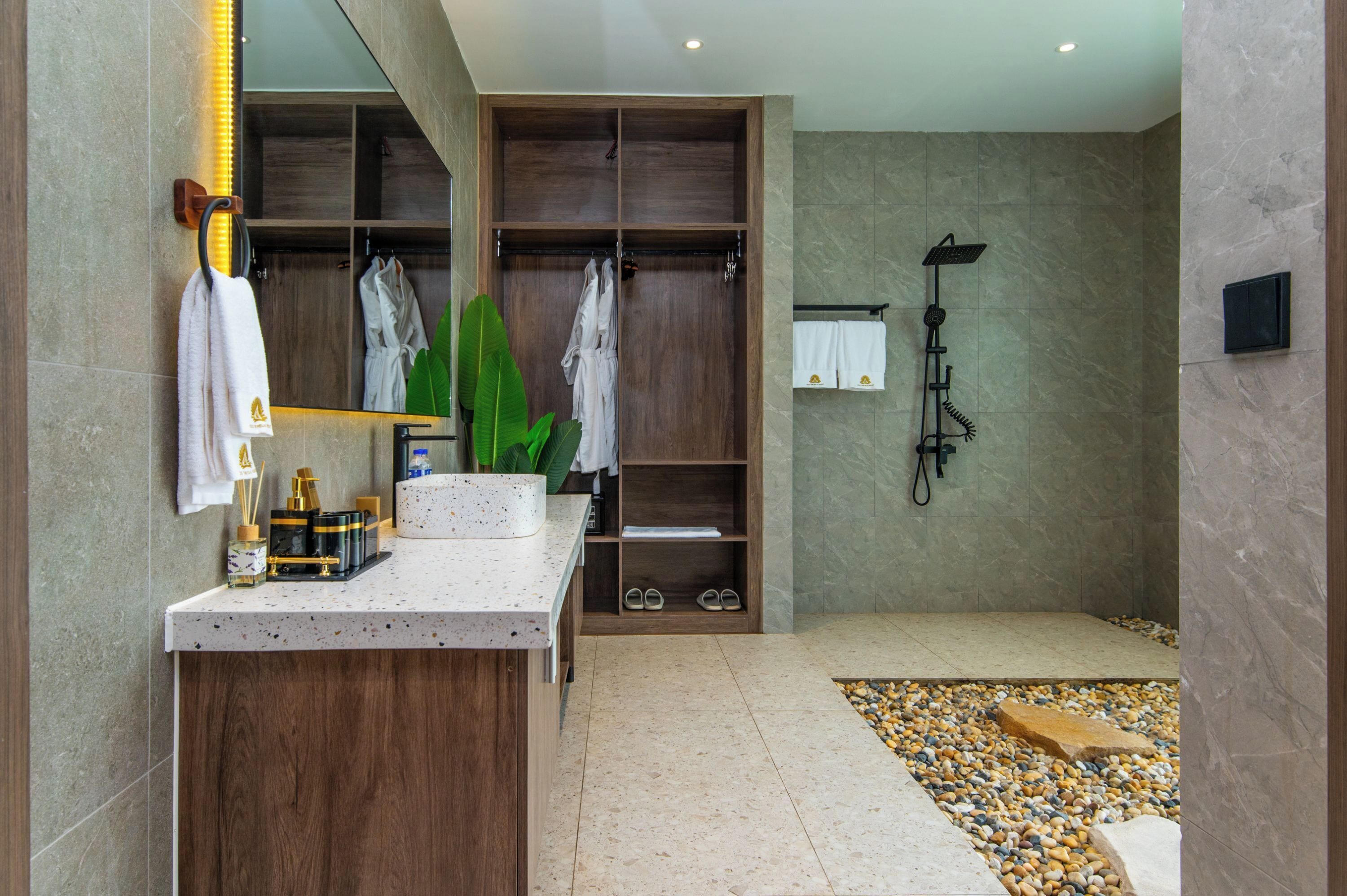 A modern bathroom with a wooden vanity, a shower, and a large mirror.