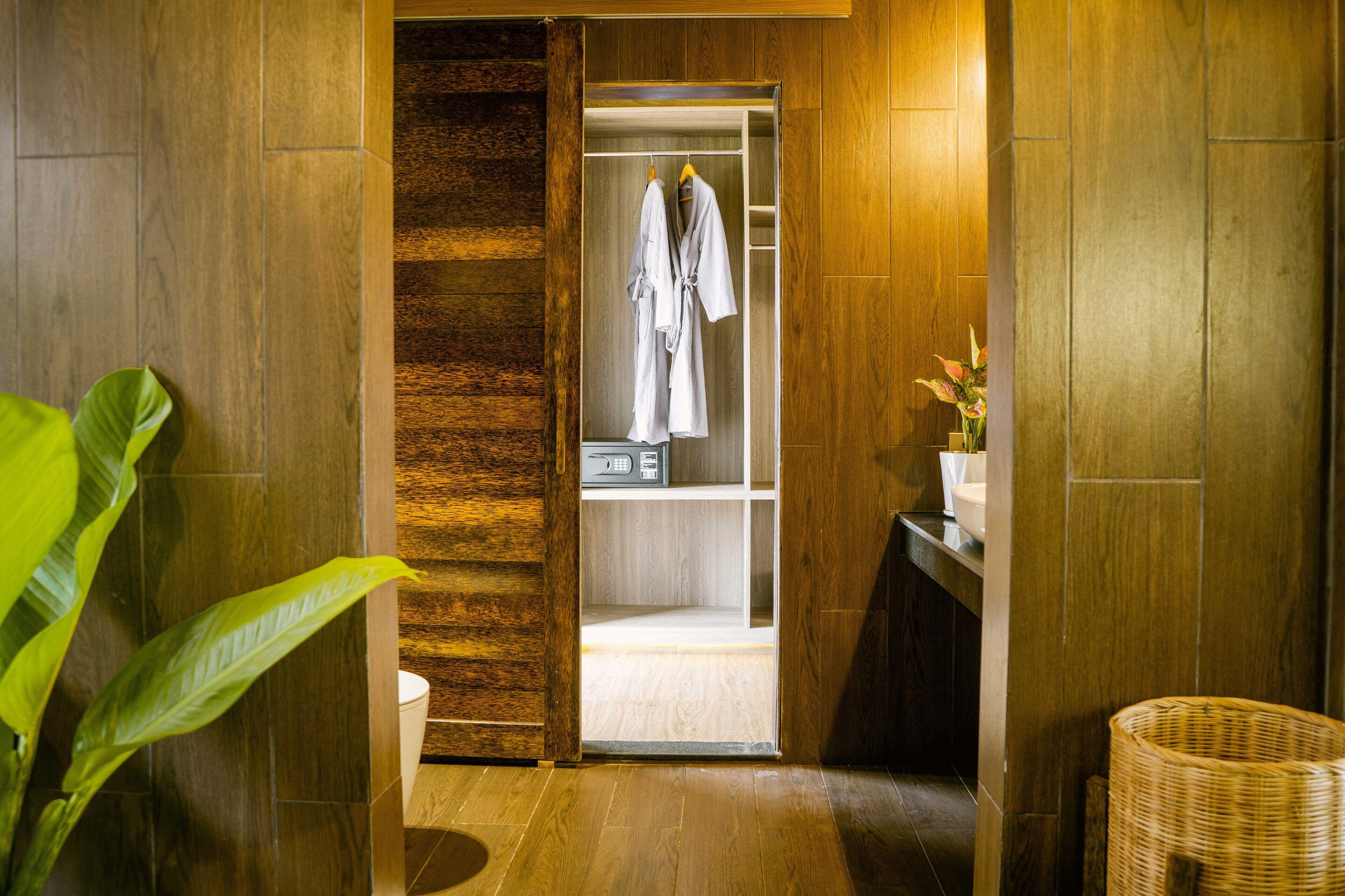 A wooden interior with a closet containing a white robe and a basket.
