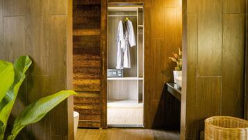 A wooden interior with a closet containing a white robe and a basket.
