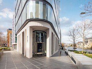 A modern building with a curved facade, a glass entrance, and a river view. - Lexicon, Angel by Interhome (London City)
