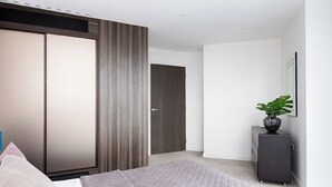 A modern bedroom with a bed, wardrobe, and dresser. - Lexicon, Angel by Interhome (London City)