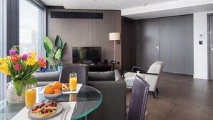 A modern hotel room with a glass dining table, a sofa, a TV, and a large window with a city view. - Lexicon, Angel by Interhome (London City)