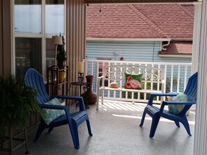 Enjoy a peaceful retreat on this balcony with two comfortable chairs, a small table, and a potted plant.