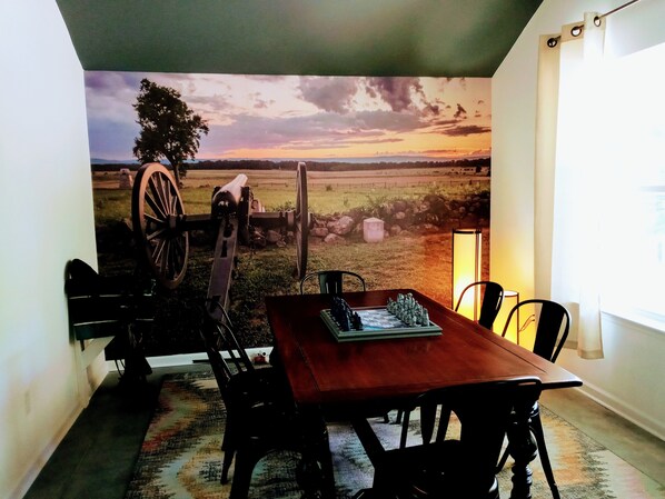 Enjoy meals in a cozy dining area with a scenic mural of a rural landscape.