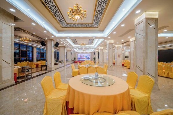 A banquet hall with round tables covered in yellow tablecloths, surrounded by yellow chairs. - Hechi Hotel (Hechi)
