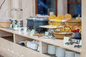 A buffet setup with various food items and serving utensils.