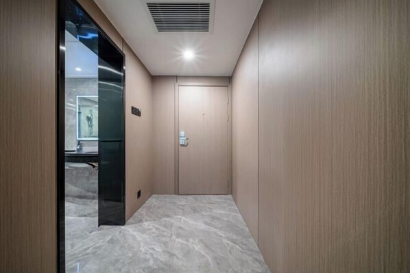 Een moderne lift met een metalen interieur en een marmeren vloer.