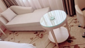 A room with a white sofa, a glass-top side table, and a floral-patterned carpet. - Vienna Hotel (Zhongshan Plaza) (Zhongshan)