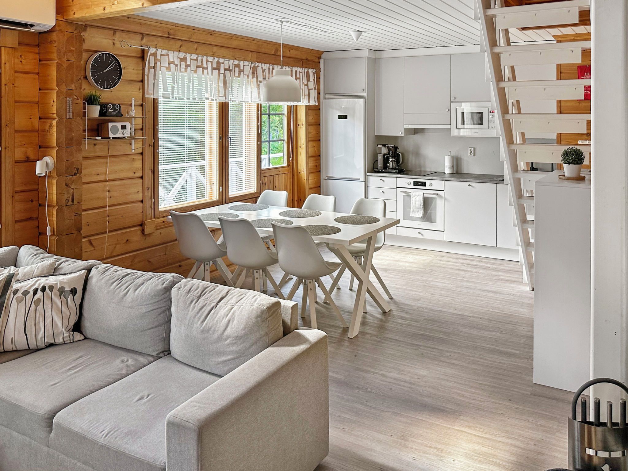 A modern kitchen with white appliances and a dining area with a white table and chairs.