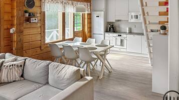 A modern kitchen with white appliances and a dining area with a white table and chairs.