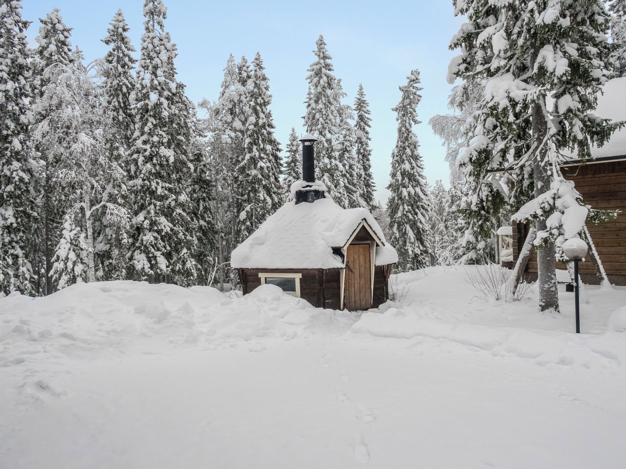 Een houten hutje, omringd door met sneeuw bedekte bomen.