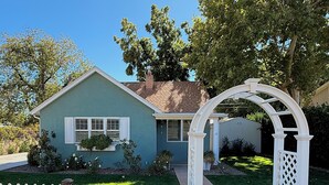 A house with a white picket fence, a front porch, and a mailbox.