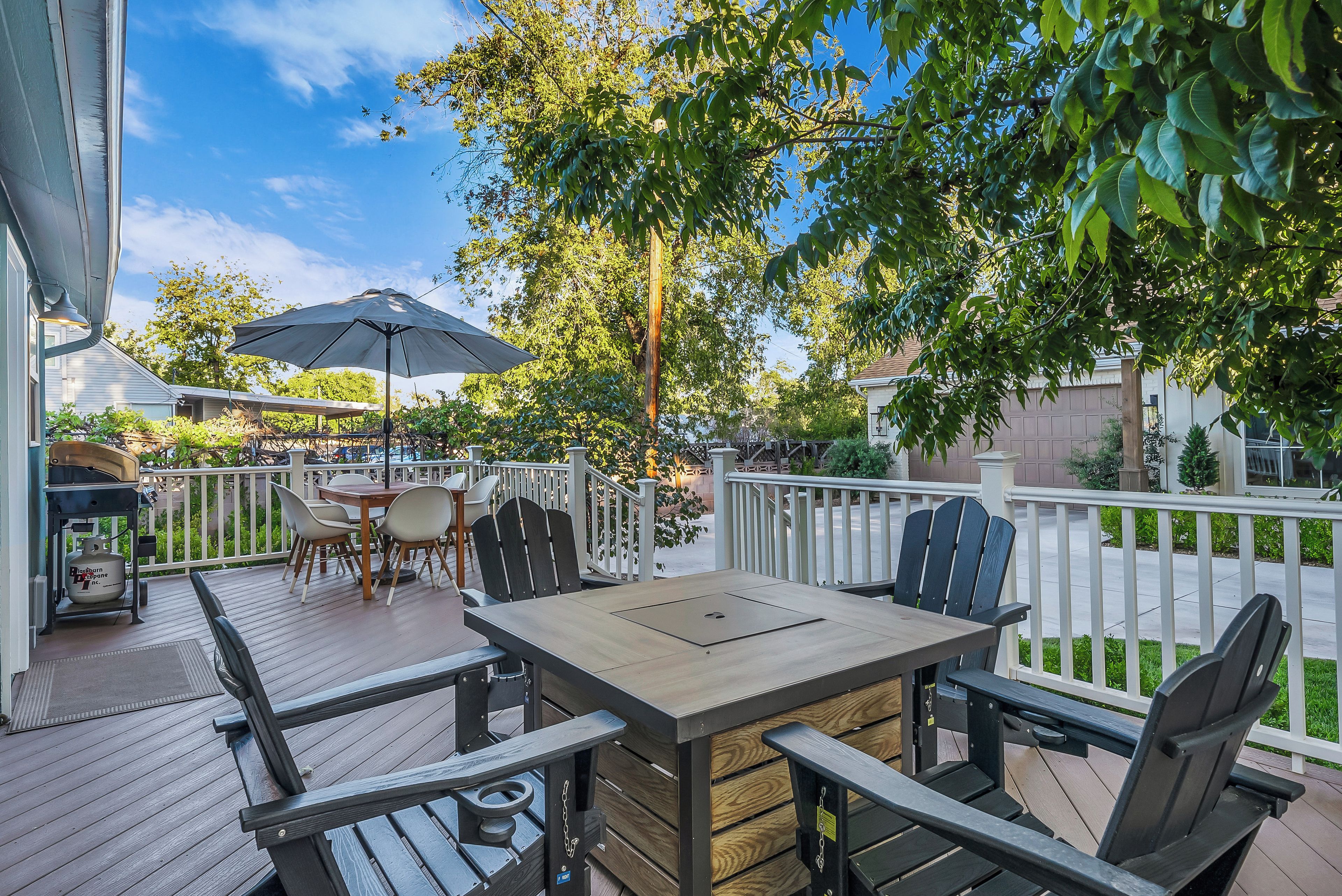 An outdoor patio with a table and chairs, a grill, and a barbecue.