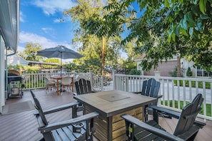 An outdoor patio with a table and chairs, a grill, and a barbecue.