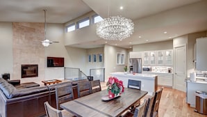 Una cocina amplia con electrodomésticos modernos, un comedor con muebles de madera y una sala de estar con un sofá grande y un televisor de pantalla plana.