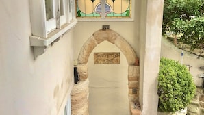 Una escalera conduce a una entrada de arco de piedra con un letrero que dice 'SANDSTONE APARTMENT'.