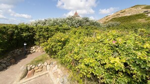 A pathway leading to a hilltop with a pagoda-like structure. - Reetdachhaus Süderende (Hörnum (Sylt))
