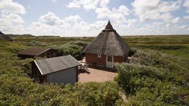 A thatched-roof building with a brick extension, surrounded by a natural landscape. - Reetdachhaus Süderende (Hörnum (Sylt))