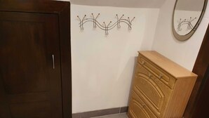 A bathroom with a wooden cabinet, a tiled floor, and a wall-mounted mirror. - Vacation in the Spreewald 2 Pers - Apartment for 2 persons (Golßen)